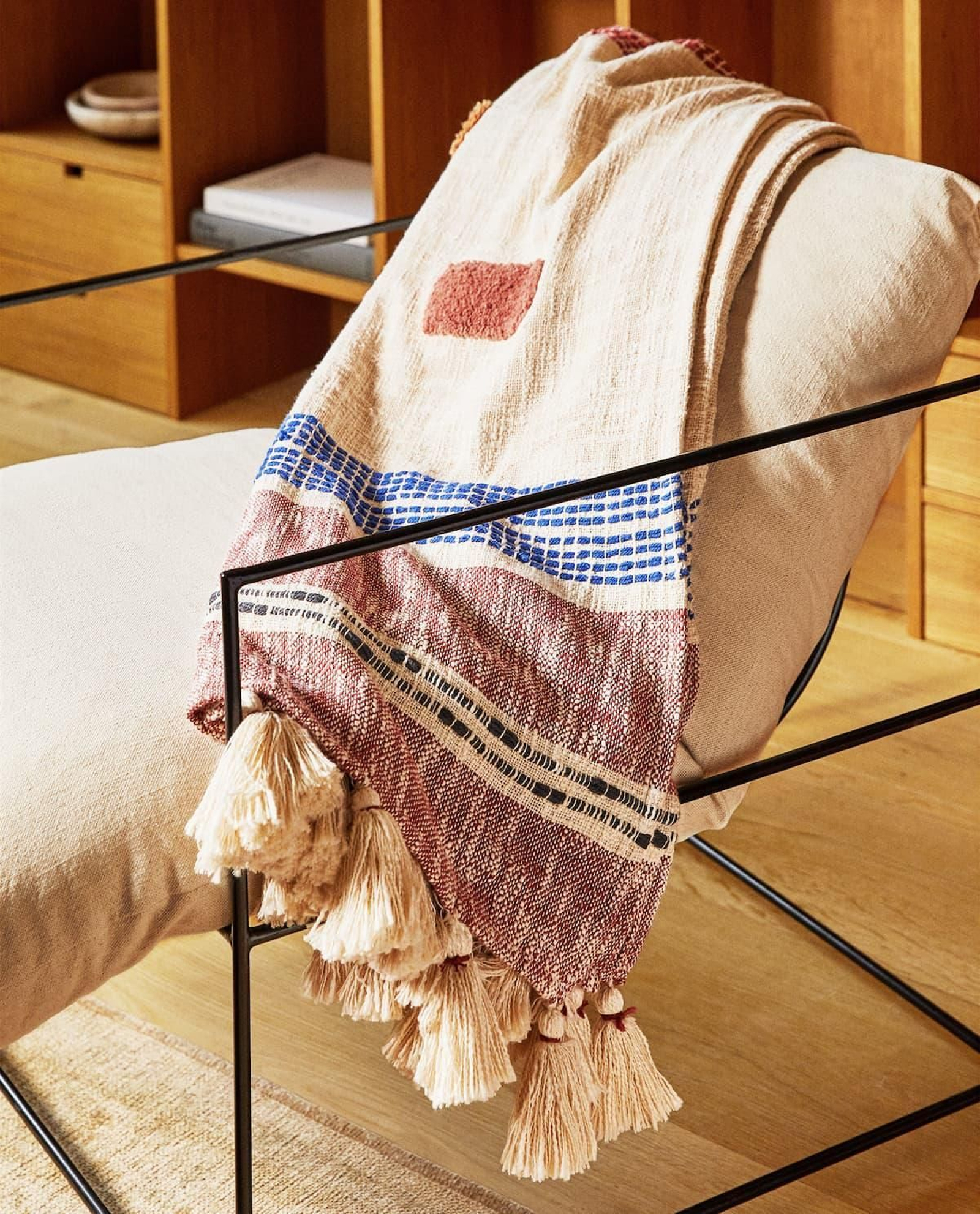 Manta con estampado y pompones.