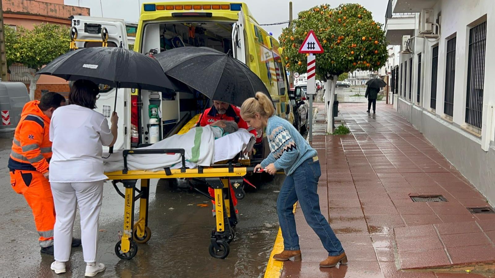 Responsables de la residencia Nuestra Señora de la Soledad y el 061 meten a una usuaria del centro en la ambulancia.