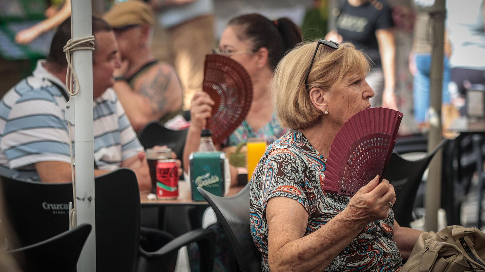 Unas señoras se abanican contra el calor.