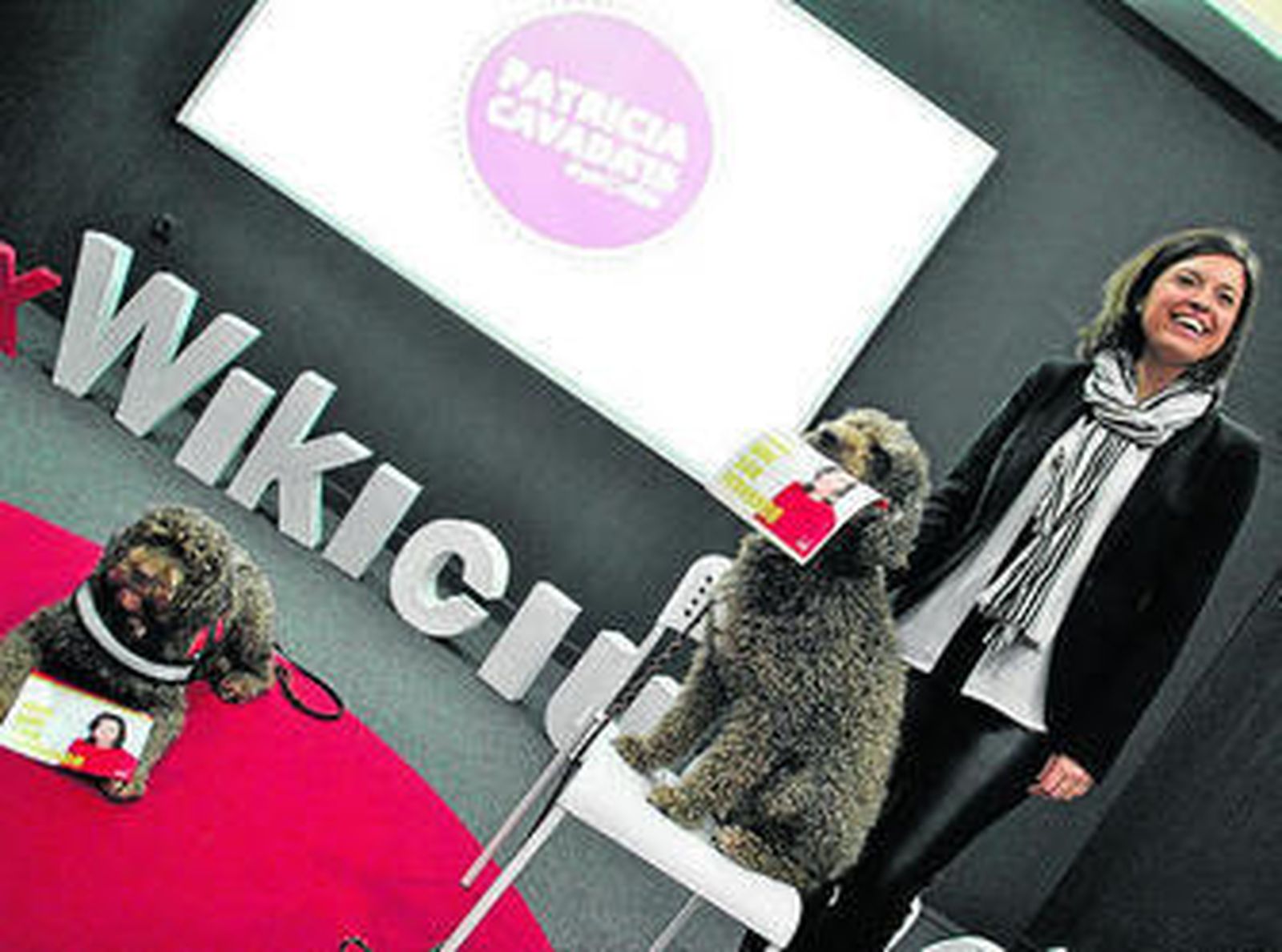 Patricia Cavada, junto a dos perros que sostienen su programa electoral.