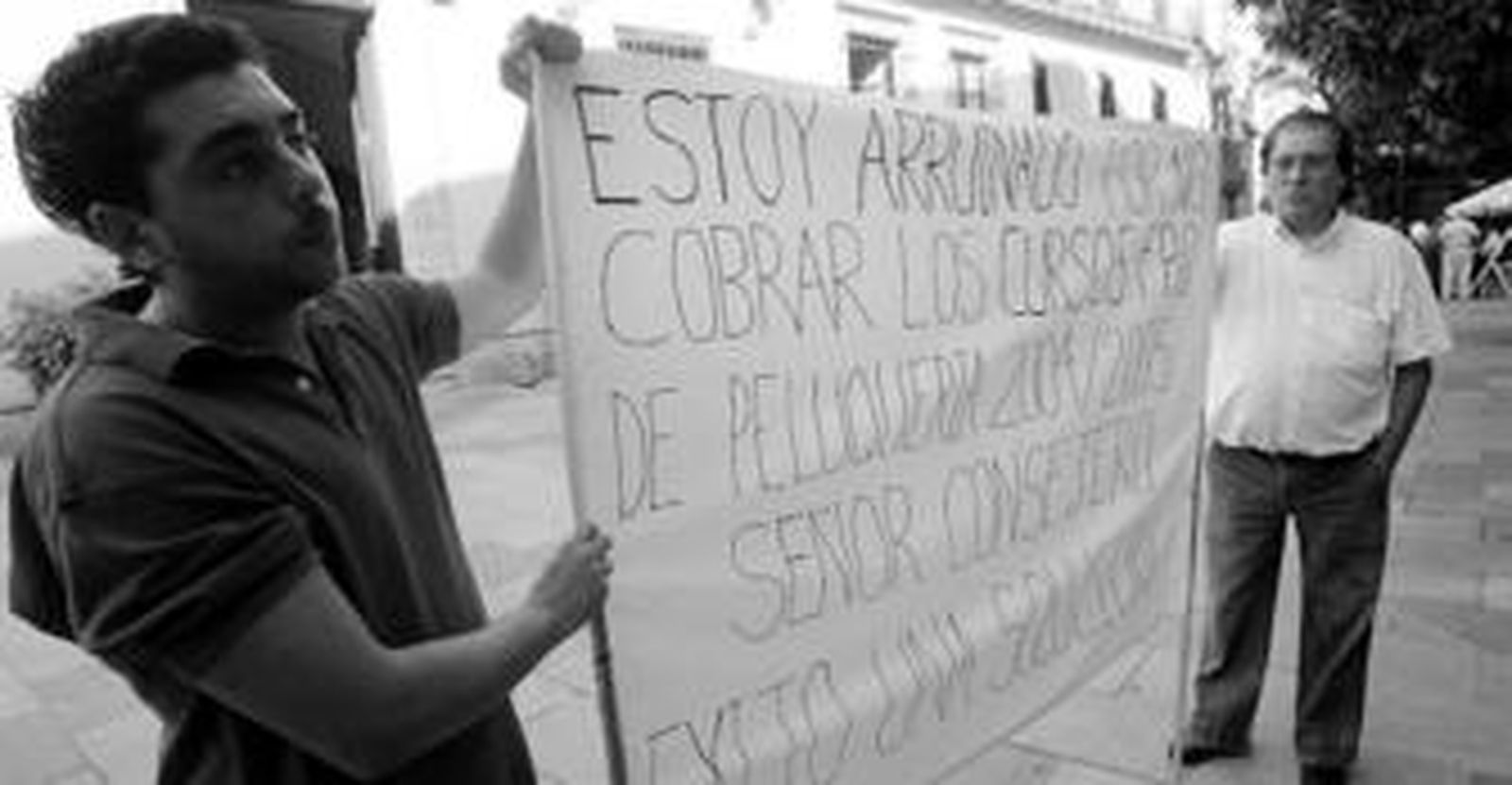 Antonio Fernández Romero -a la derecha de la imagen-, ayer con una pancarta delante del Ayuntamiento.