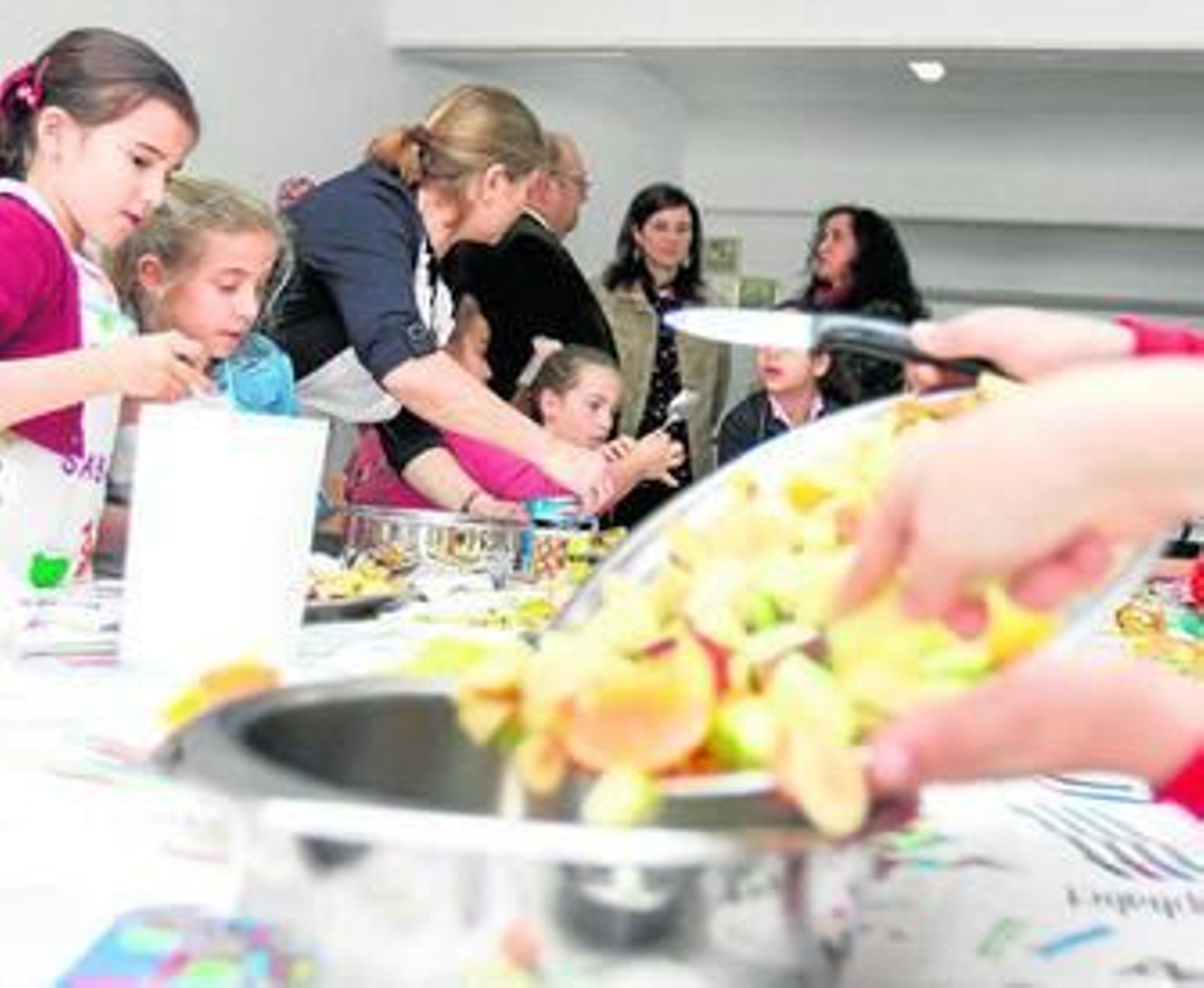 La delegada de Educación y responsables del centro con los alumnos durante un programa de cocina.