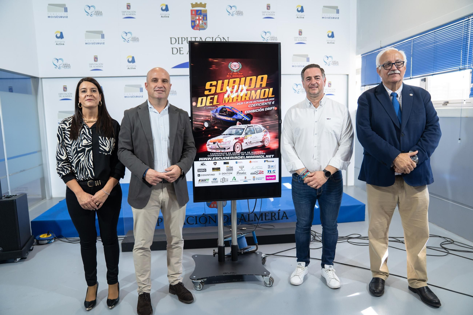 Los representantes institucionales y de la organización posan junto al cartel de la prueba durante su presentación.