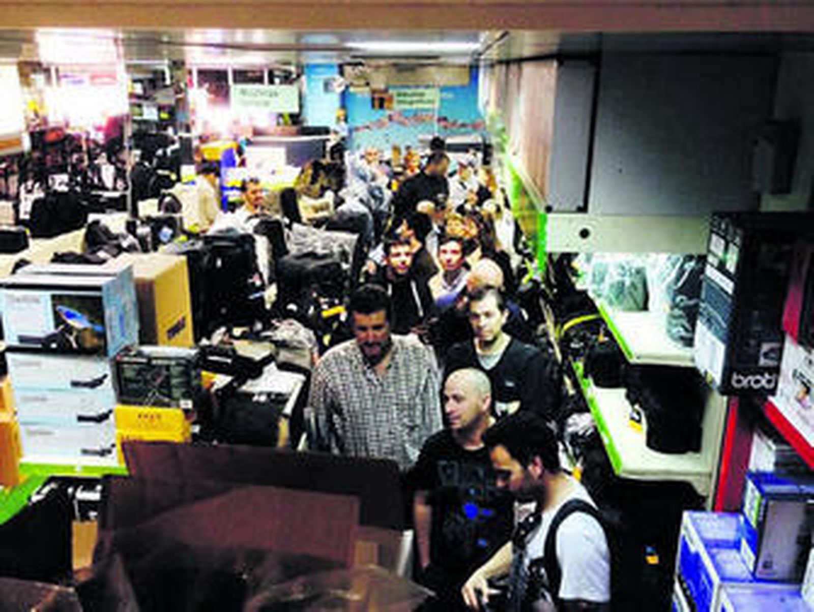 1. Largas colas a las puertas de la tienda de Martín Iglesias en las inmediaciones de Luis Montoto 2. El establecimiento, abarrotado de interesados en participar.