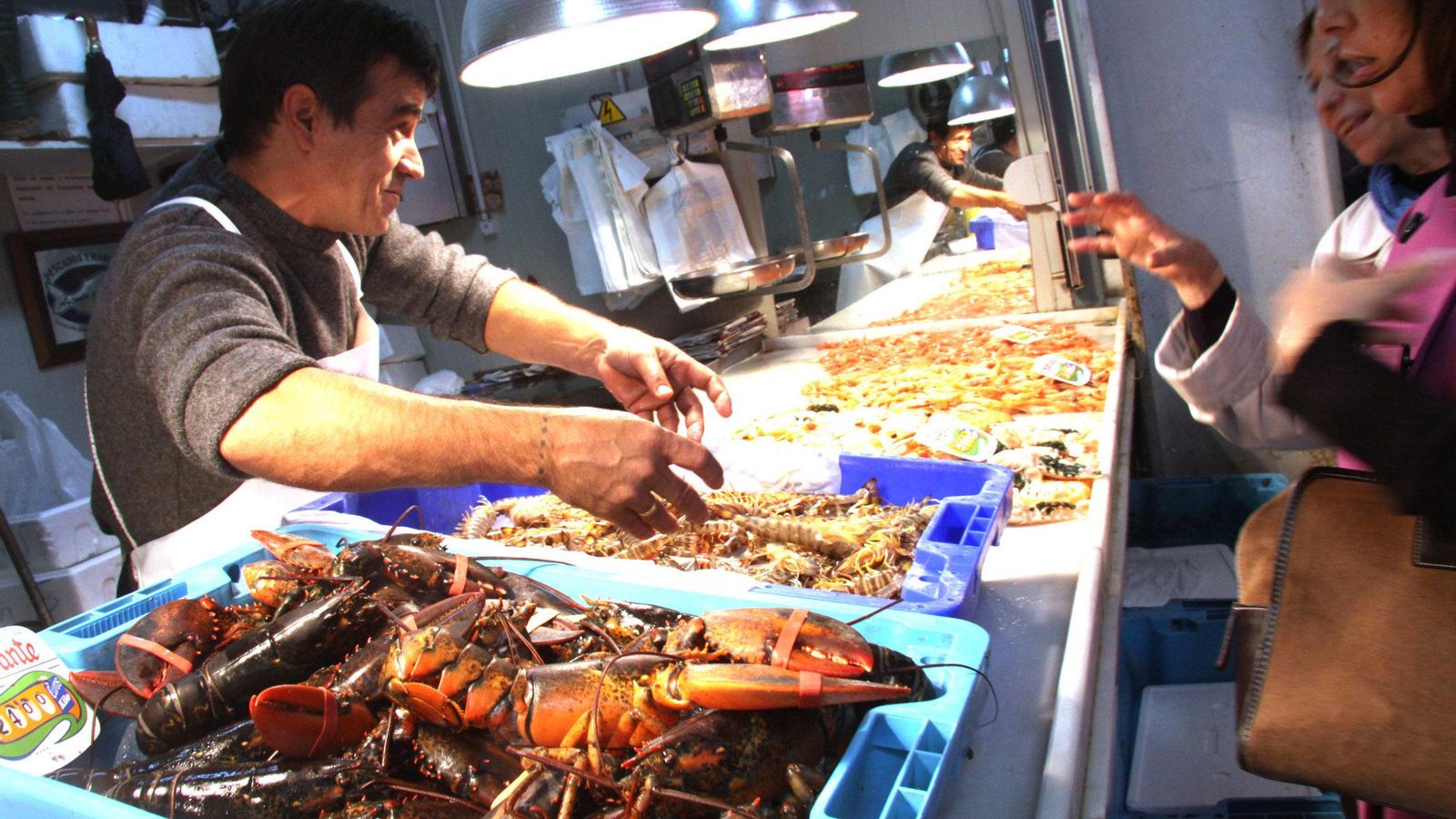 Un pescadero atiende a sus clientes