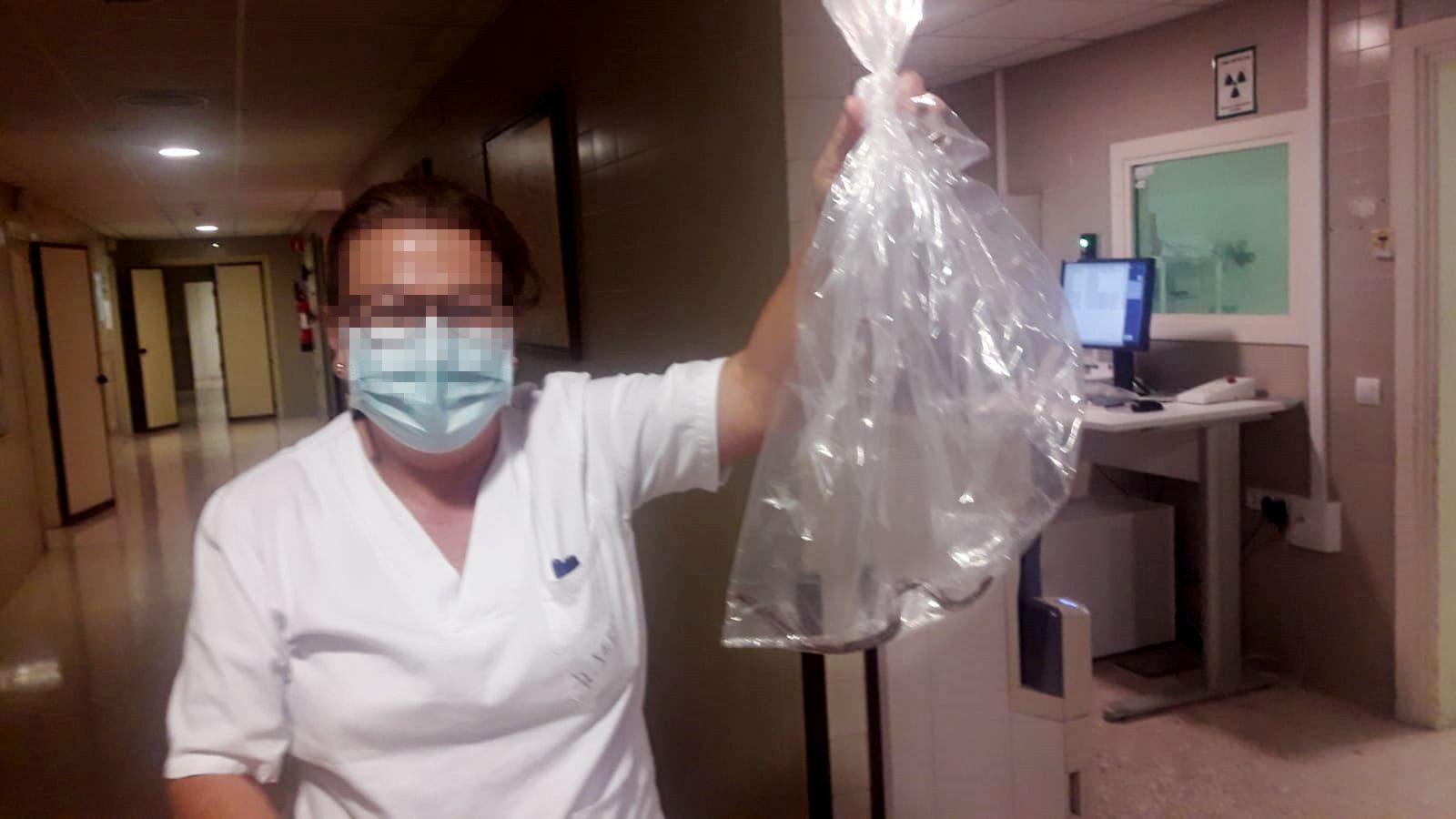 Una trabajadora sujeta la bolsa con la culebra dentro.