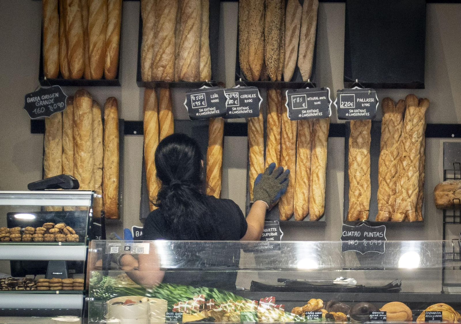 Una empleada de una panadería atendiendo a clientes