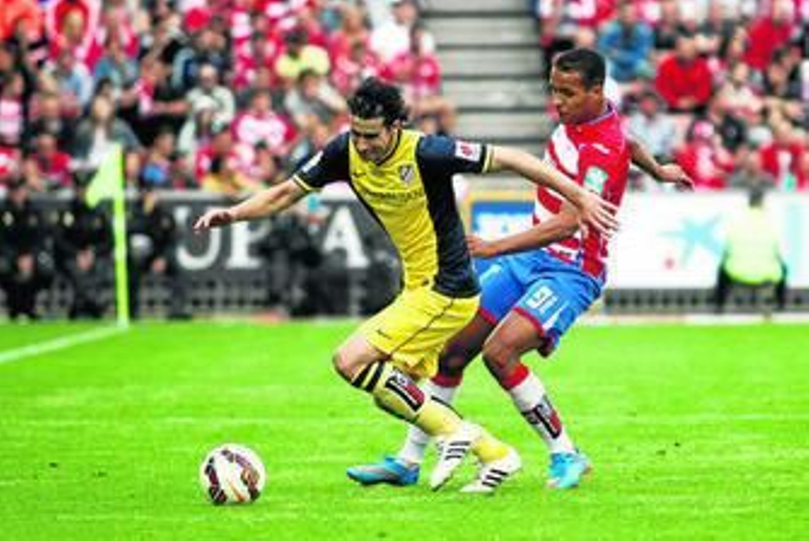 El Arabi persigue a Tiago en el duelo disputado ayer en Los Cármenes.