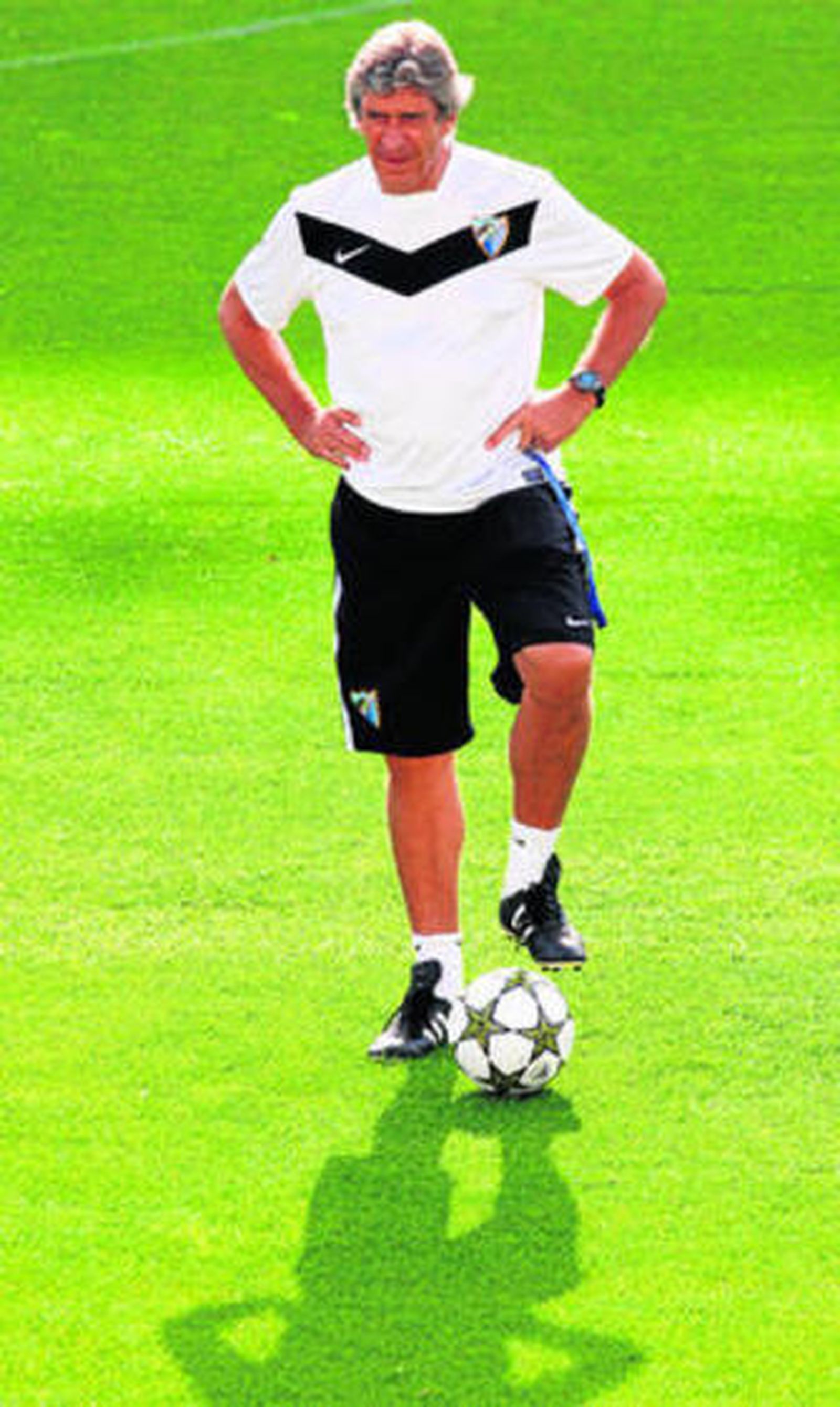 Manuel Pellegrini pisa un balón mientras observa a sus jugadores ejercitarse.