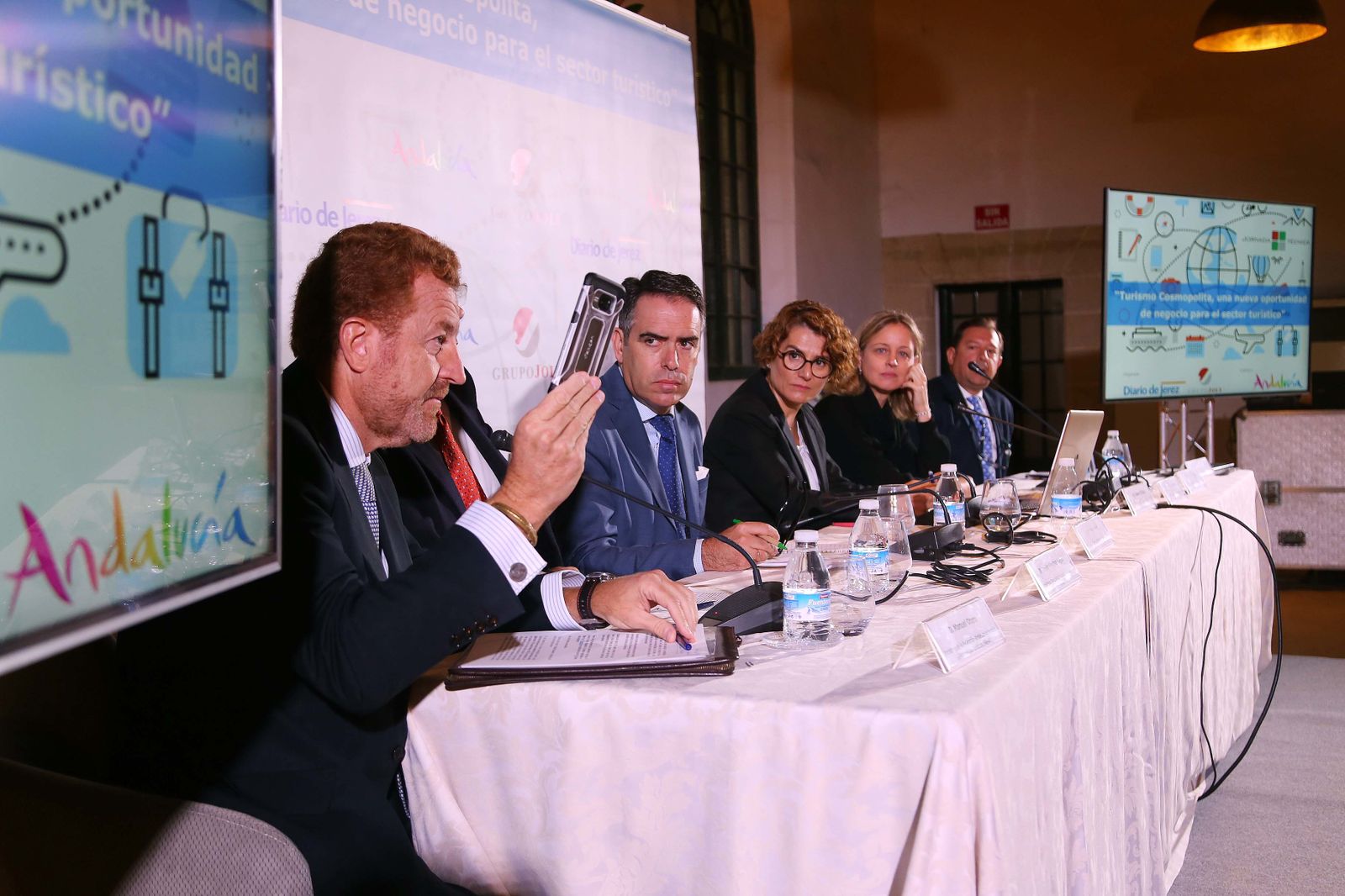 Manuel Otero muestra su móvil a los presentes durante la mesa de debate.