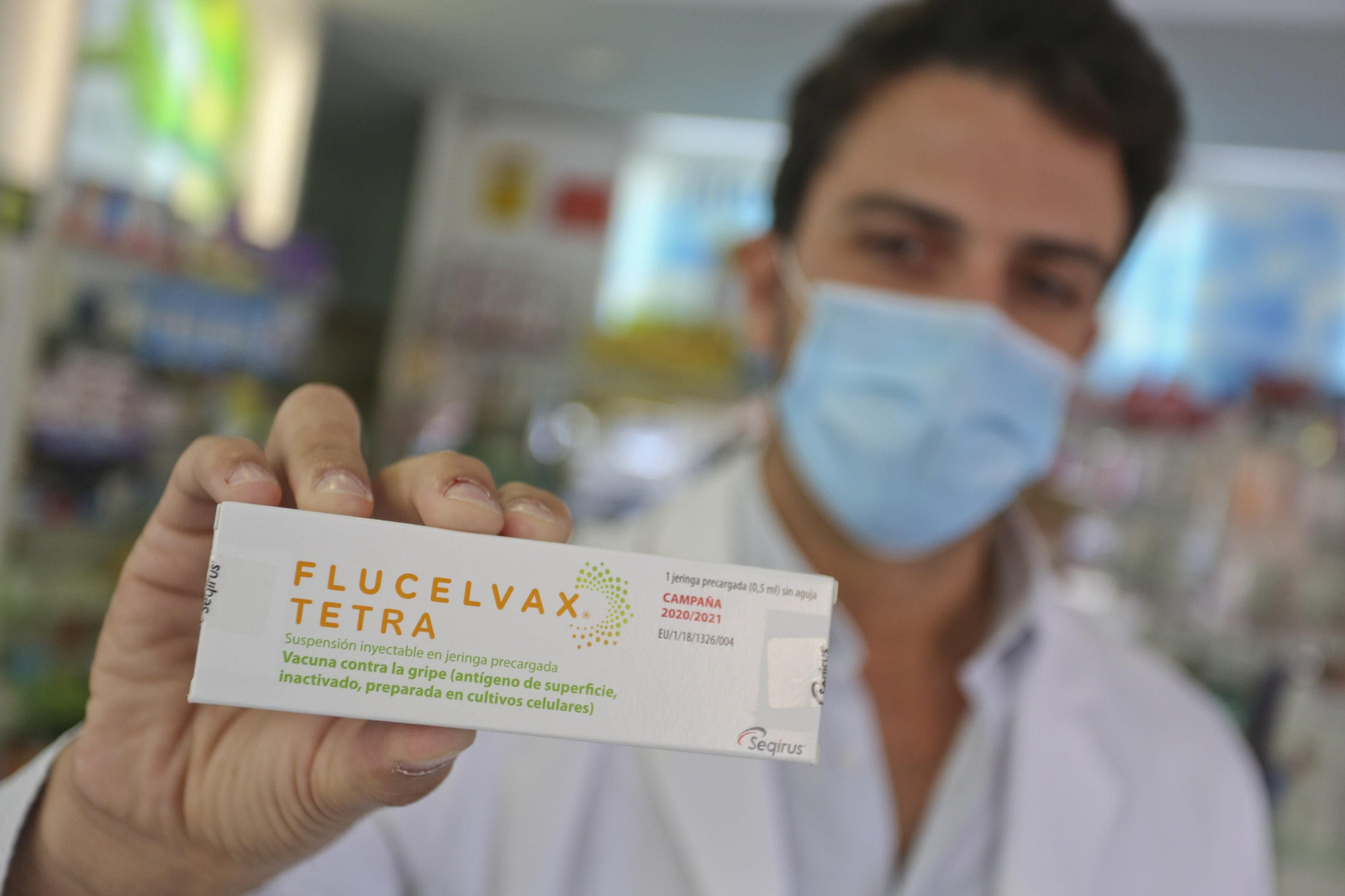 Un sanitario de una farmacia muestra una de las pocas vacunas de la gripe que han llegado a las boticas malagueñas.