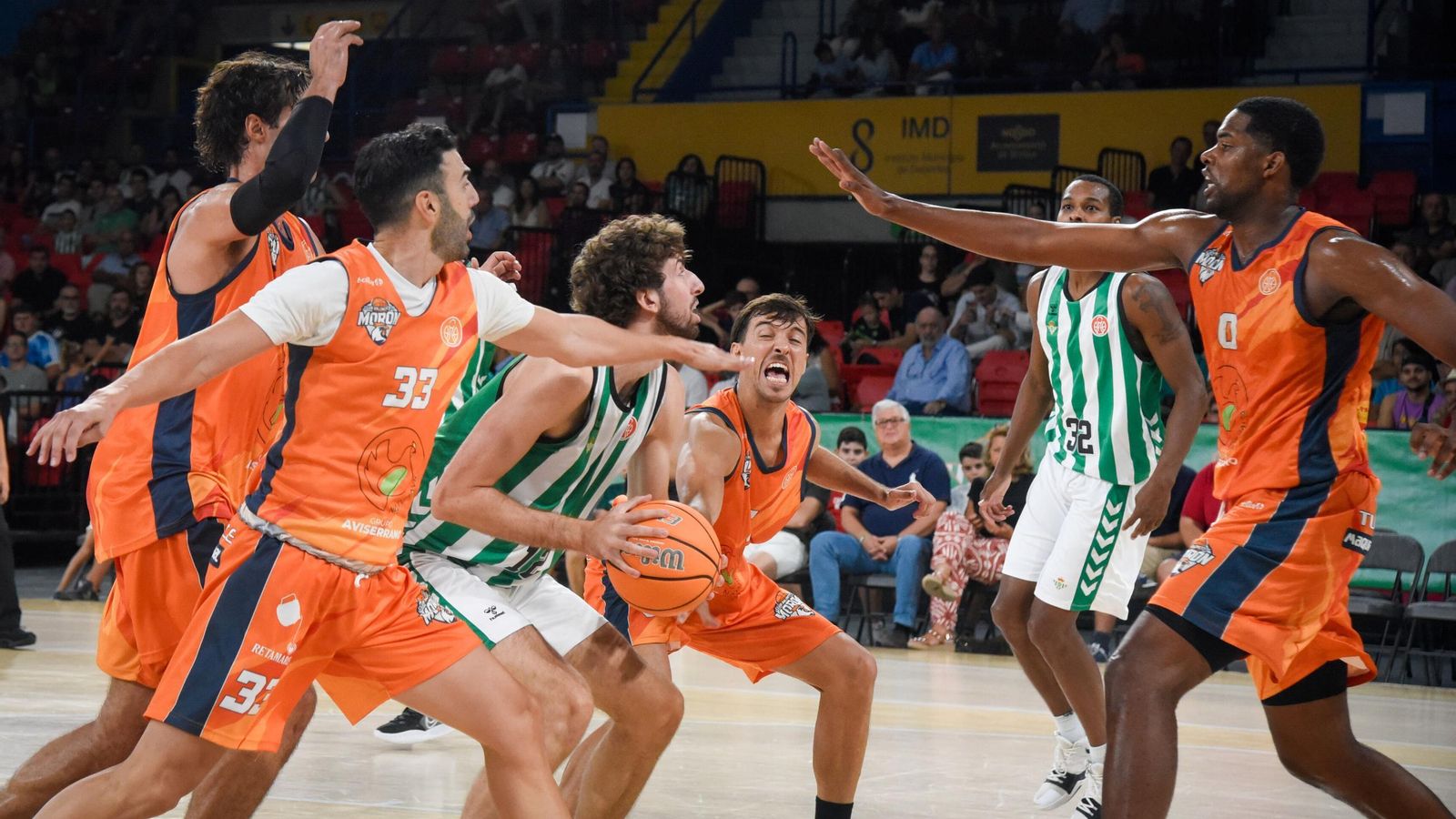 La defensa del CB Morón trata intensamente de recuperar la posesión ante el Betis Baloncesto.