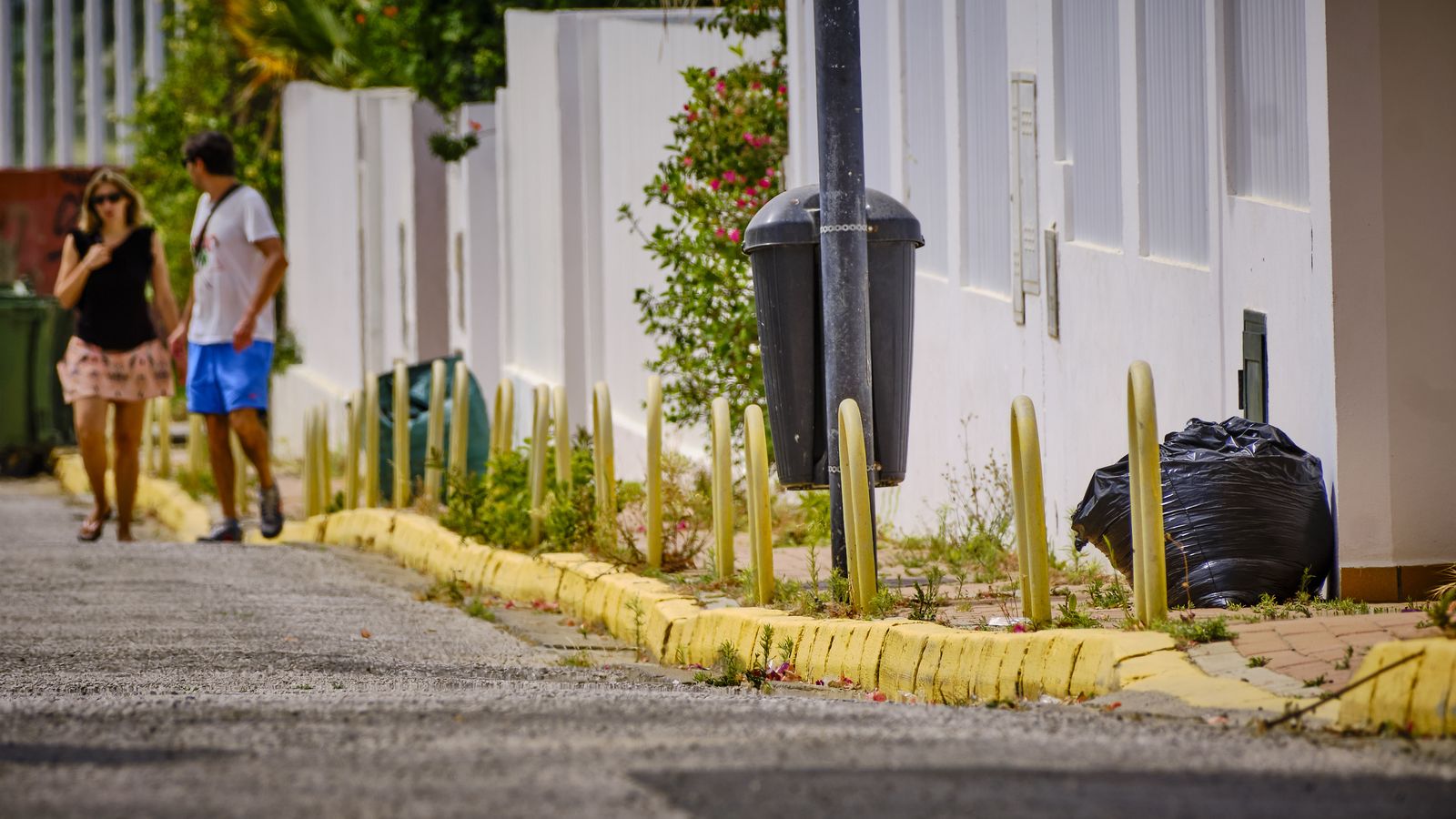 Bolsas de basura y restos de poda, acumuladas en una de las calles de la urbanización.