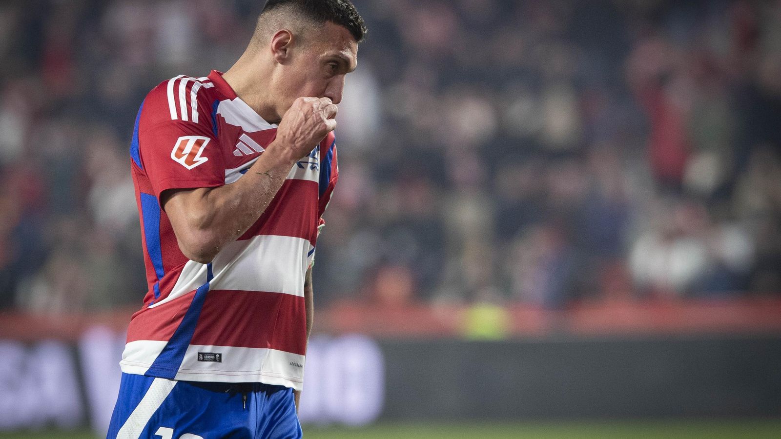 Uzuni se besa el escudo celebrando su último gol con el Granada