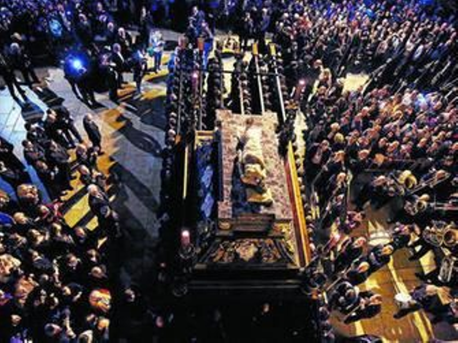 La muchedumbre rodea al Señor del Sepulcro tras su salida.
