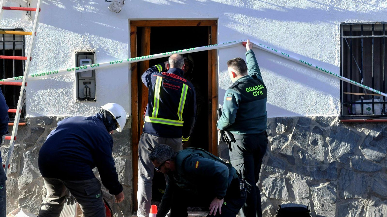 Bomberos y guardias civiles, a la entrada de la casa.