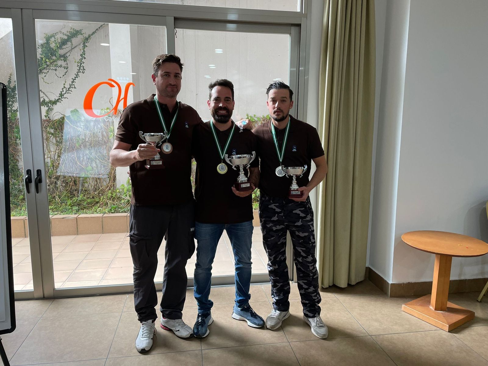 Los tres primeros clasificados, con sus trofeos