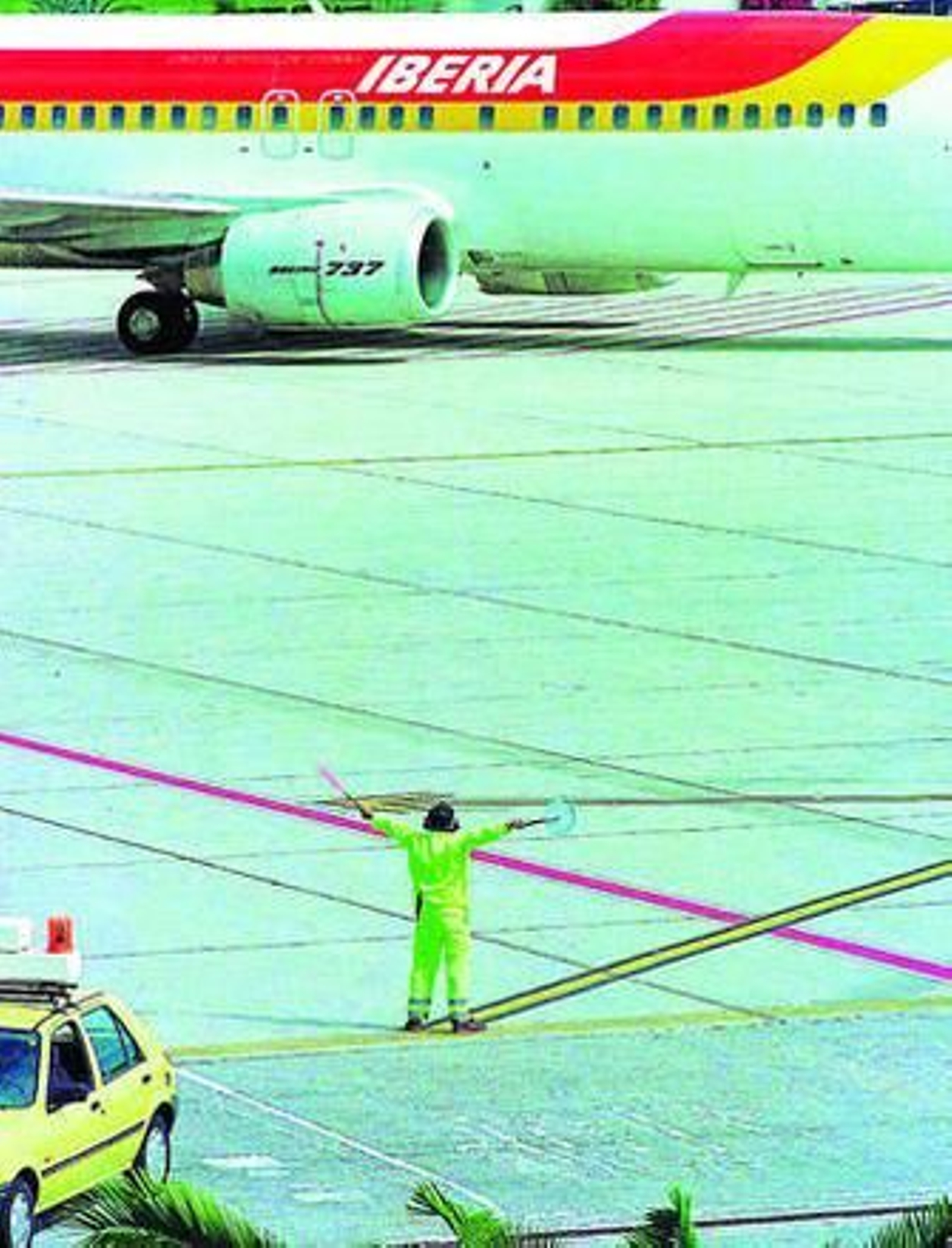 Un operario de pista conduce a las inmediaciones de la terminal a un Boeing 737 de la compañía Iberia.