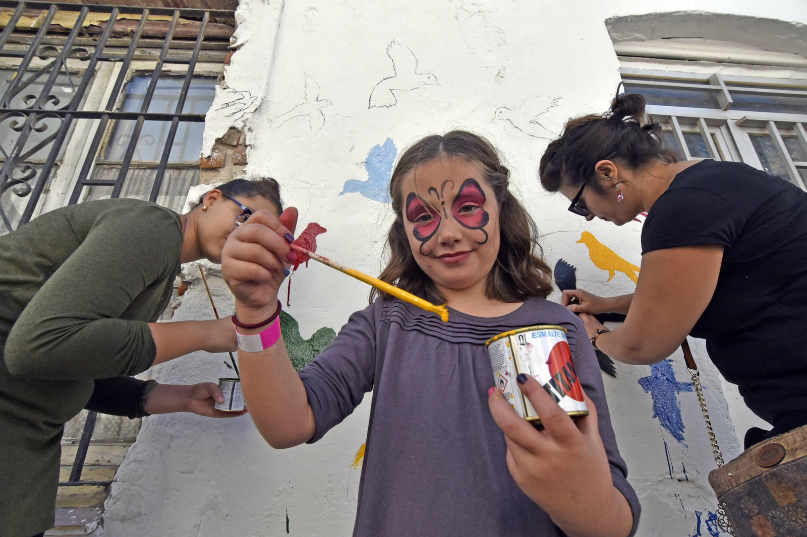 Una niña participa en el embellecimiento de una fachada en Cayetano del Toro, este sábado.