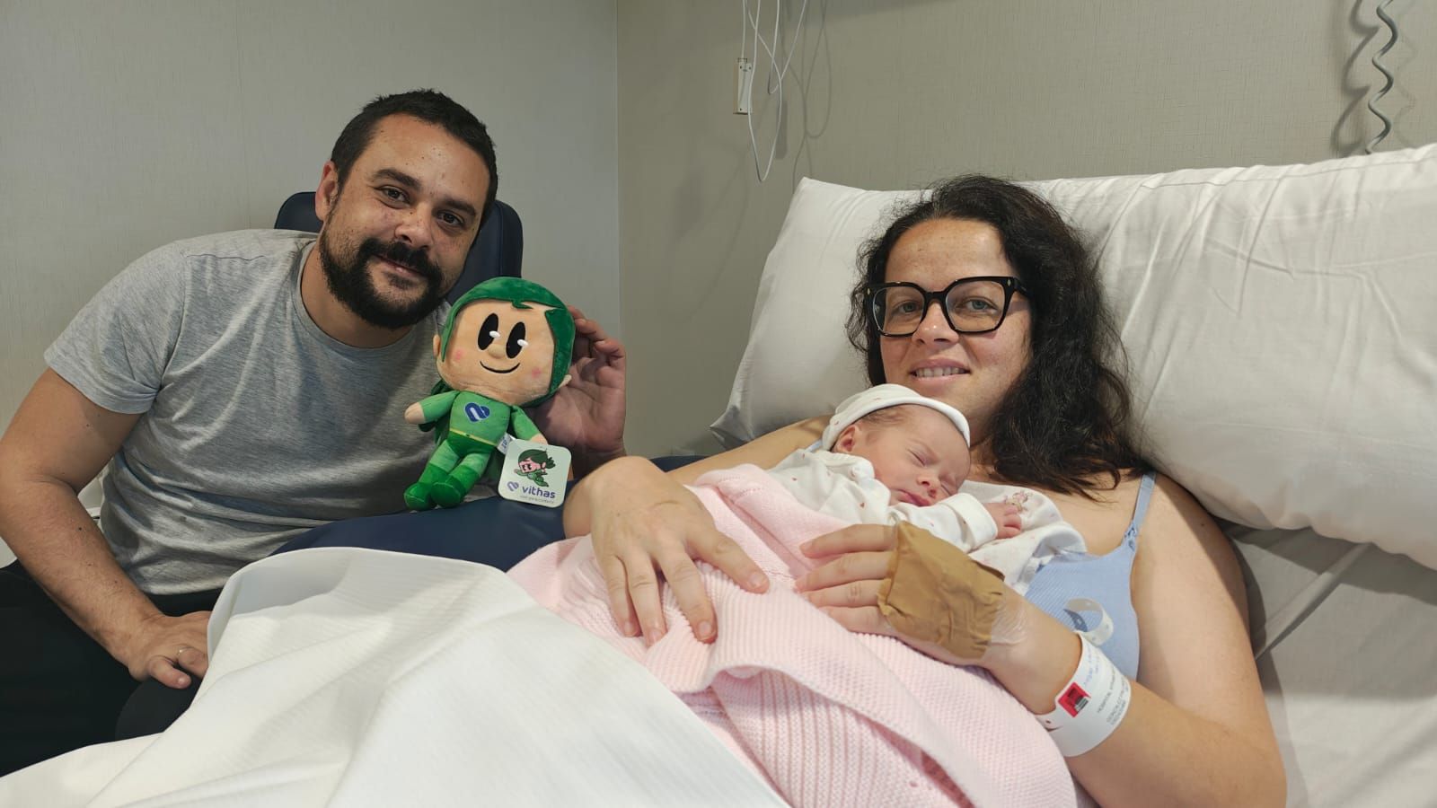 María González sostiene en sus brazos a la pequeña Alma junto a su padre, en la habitación del hospital
