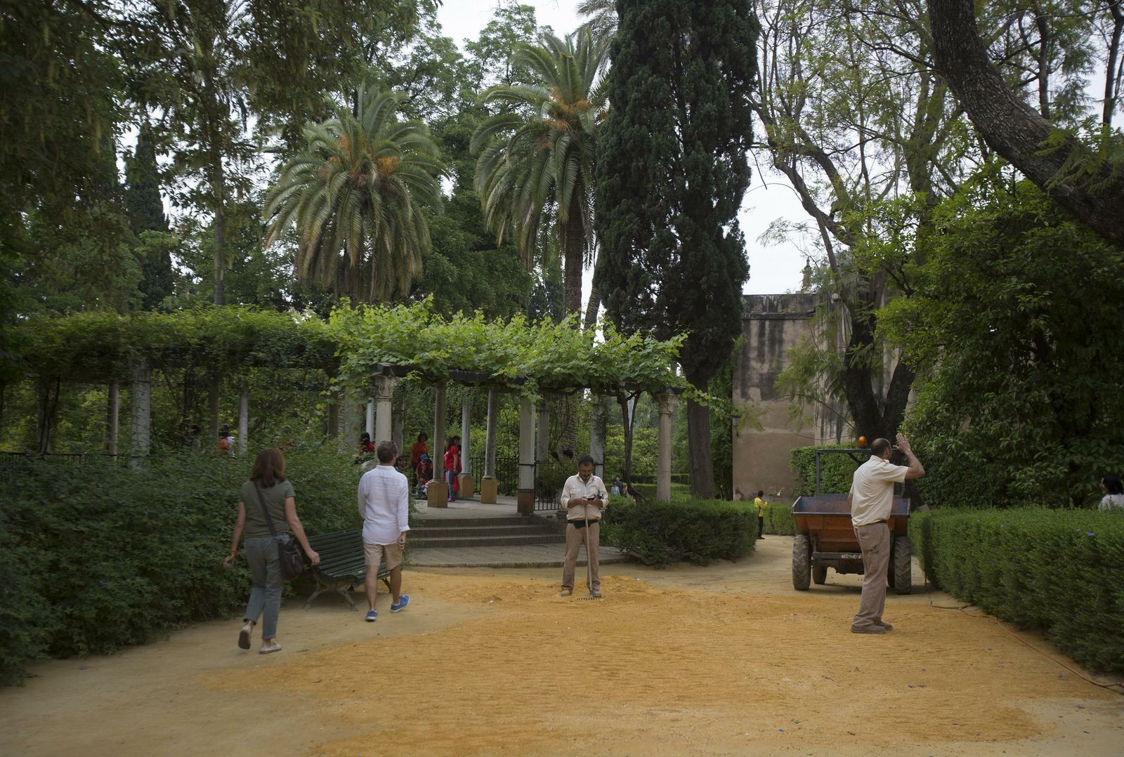 Varias personas en los jardines del Real Alcázar.