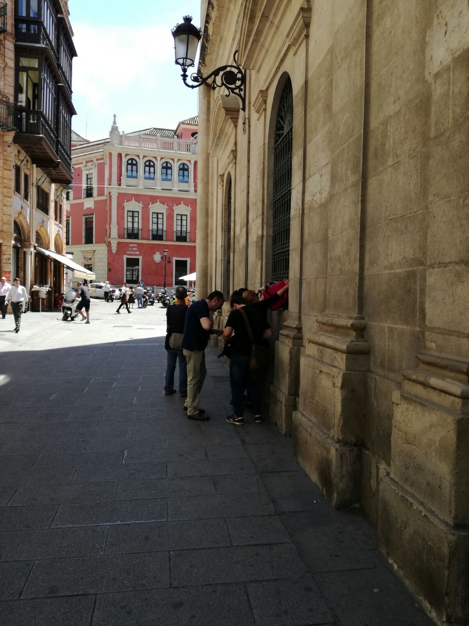 Varias personas meten mochilas por la ventana de las dependencias de Participa Sevilla.