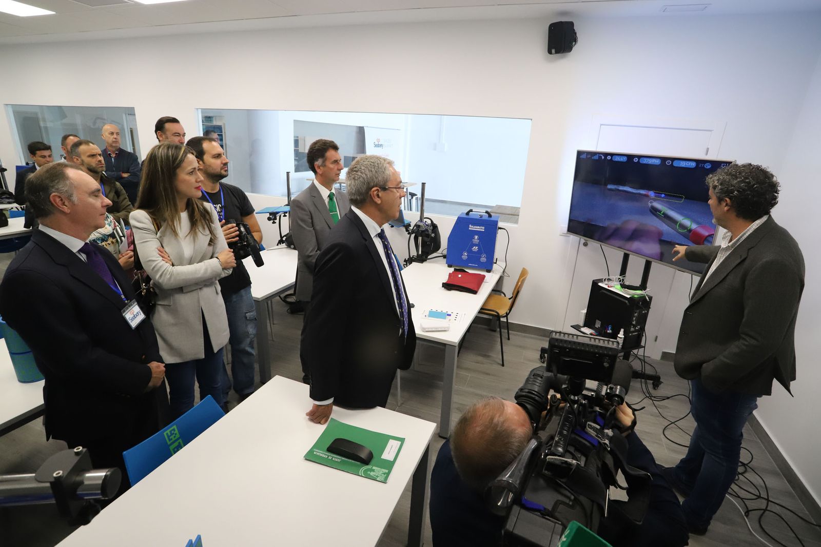 El consejero y otras autoridades reciben explicaciones de un programa diseñado por Seabery.