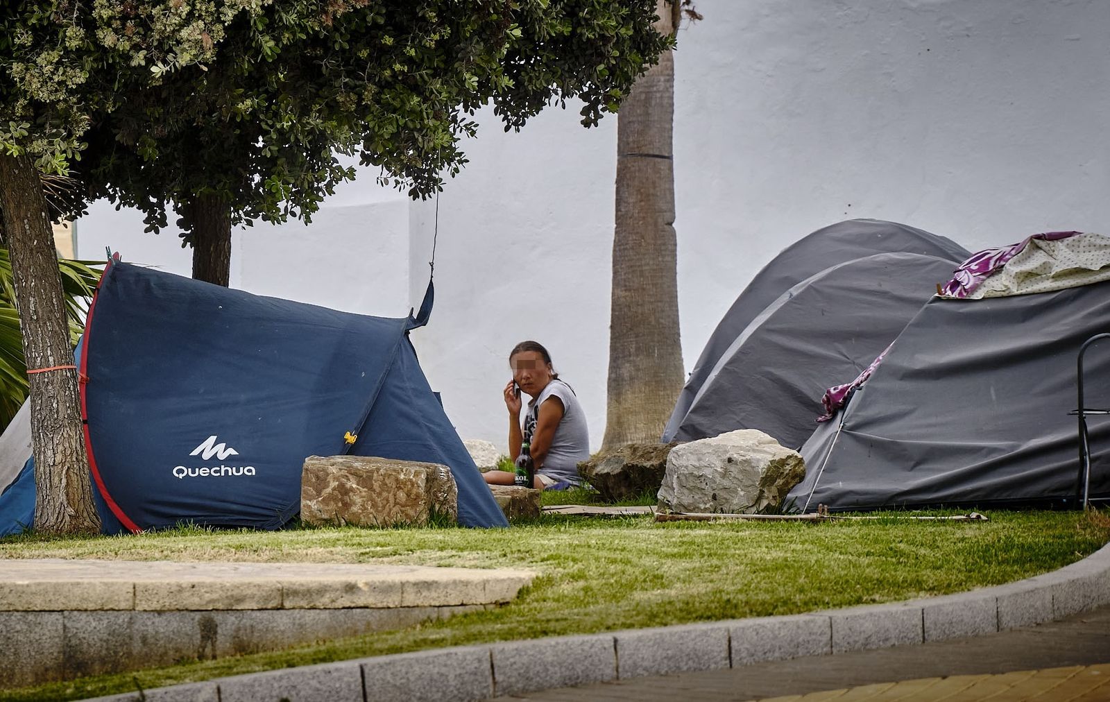 Una persona sin hogar, en una zona con varias tiendas de campaña, en una imagen de archivo.