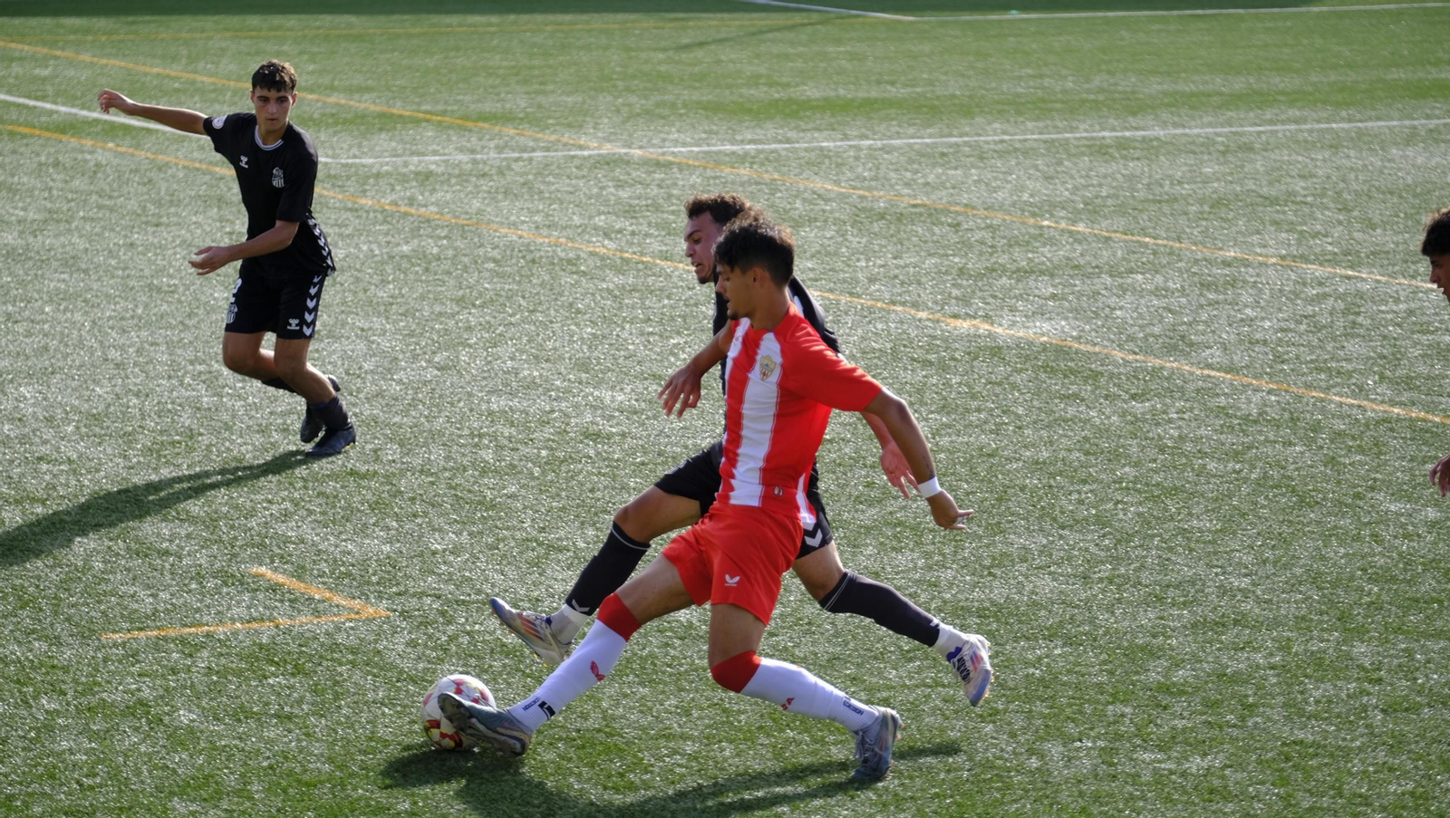 Un jugador del conjunto rojiblancos intenta irse de un rival en una acción del segundo tiempo en el encuentro en el Francisco Pomedio.