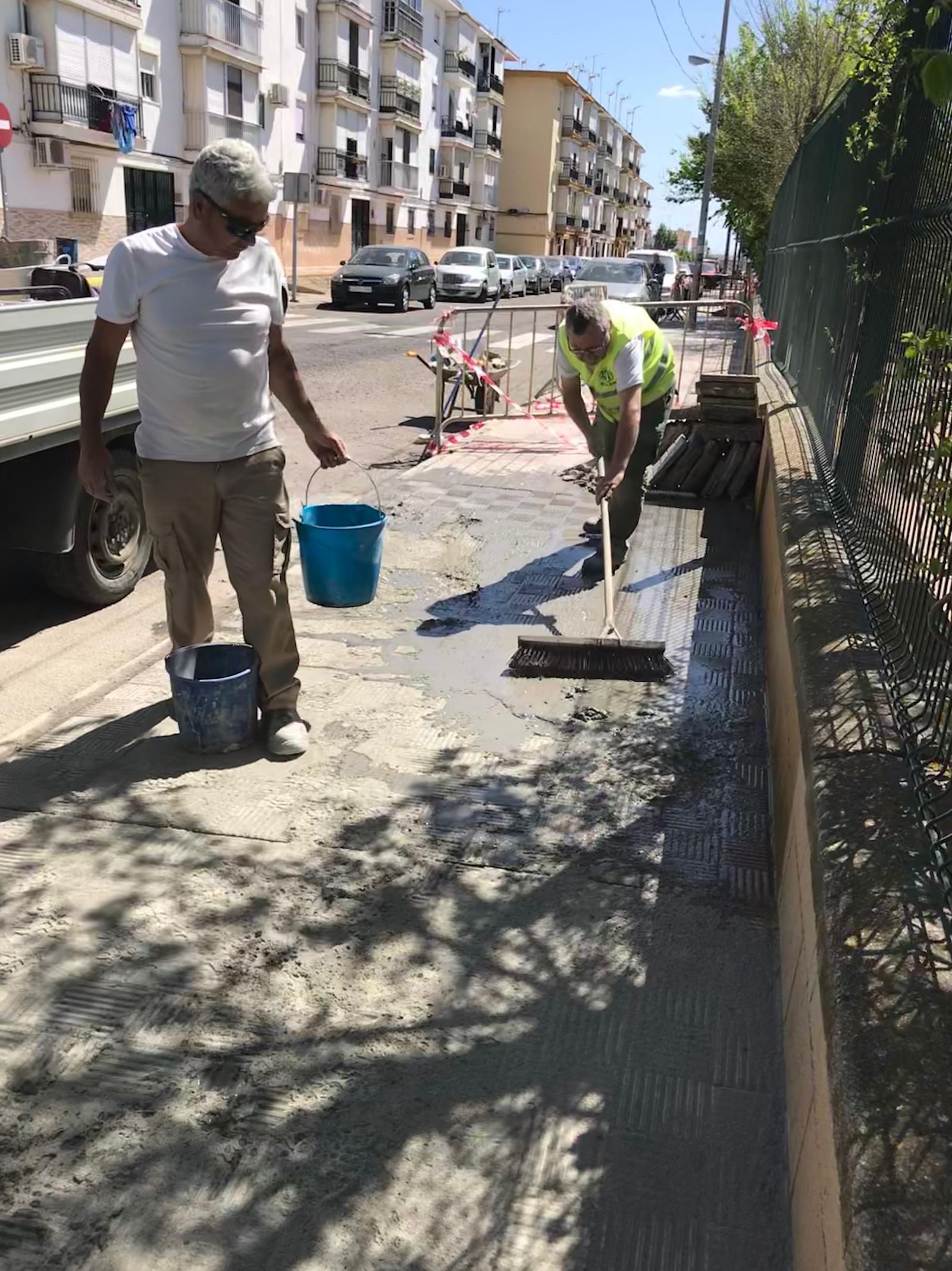 Operarios realizan labores de mantenimiento en las aceras de la localidad sevillana.