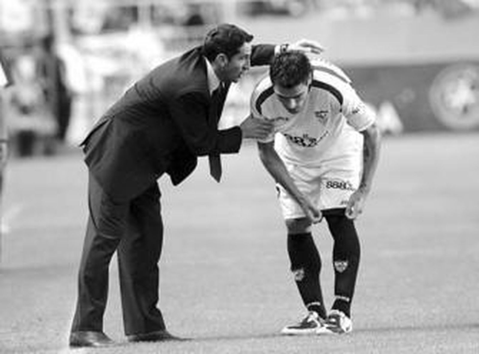 Manolon Jiménez le da instrucciones a Duscher en el césped del Sánchez Pizjuán.