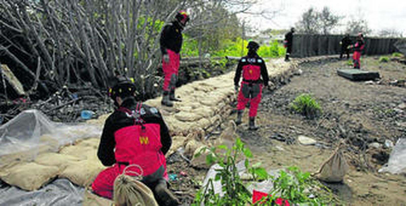 Un grupo de miembros de la Unidad Militar de Emergencias (UME) construyen un dique en la ribera del Genil, ayer por la mañana.