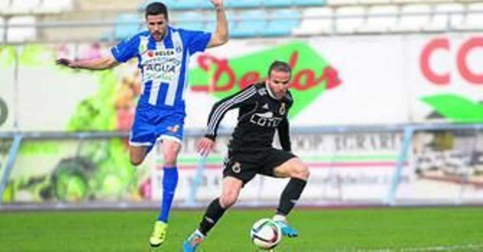 El autor del gol, Juampe (d), elude la vigilancia de un jugador de La Hoya, ayer en Lorca.
