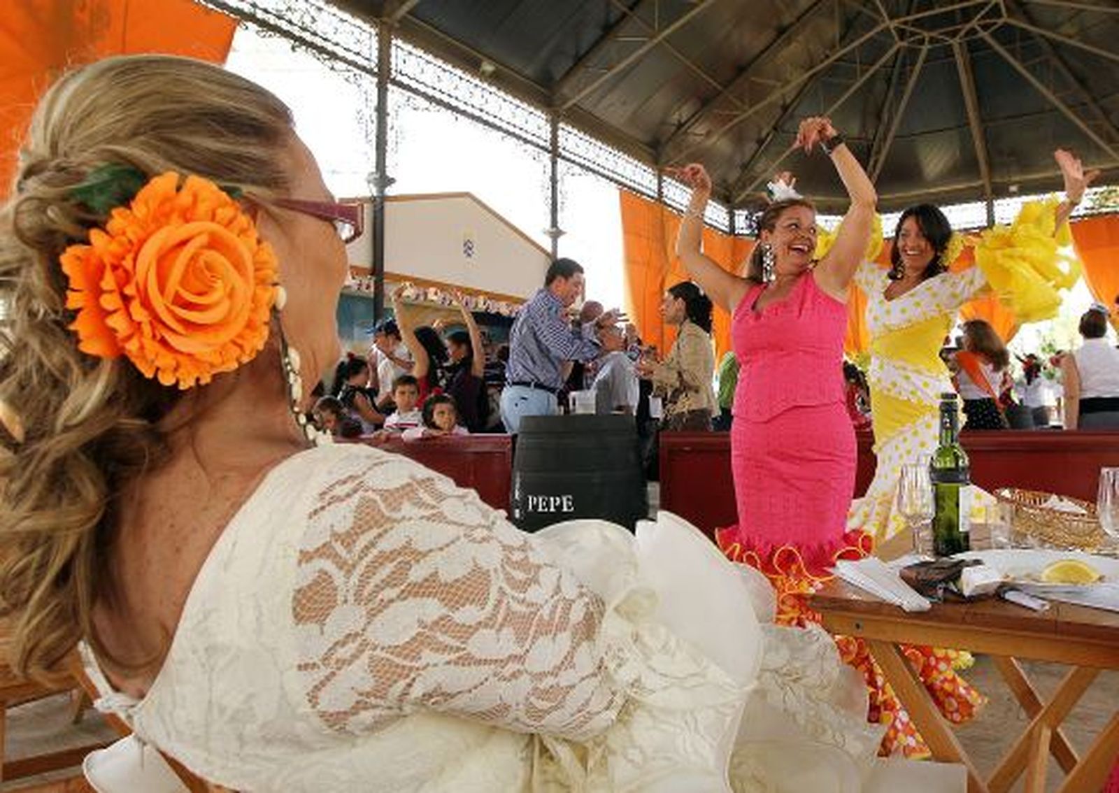 Dos mujeres bailan sevillanas en el templete municipal mientras una tercera las mira.

Foto: miguel ángel gonzález