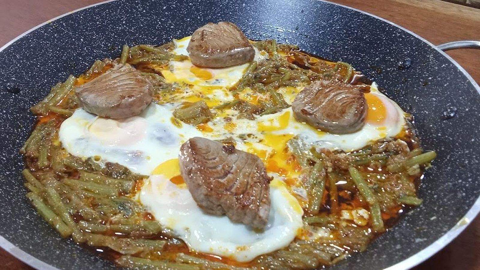 Alcachofas confitadas o las tagarninas esparragás acompañadas con su huevo cuajado y con tacos de morrillo de atún