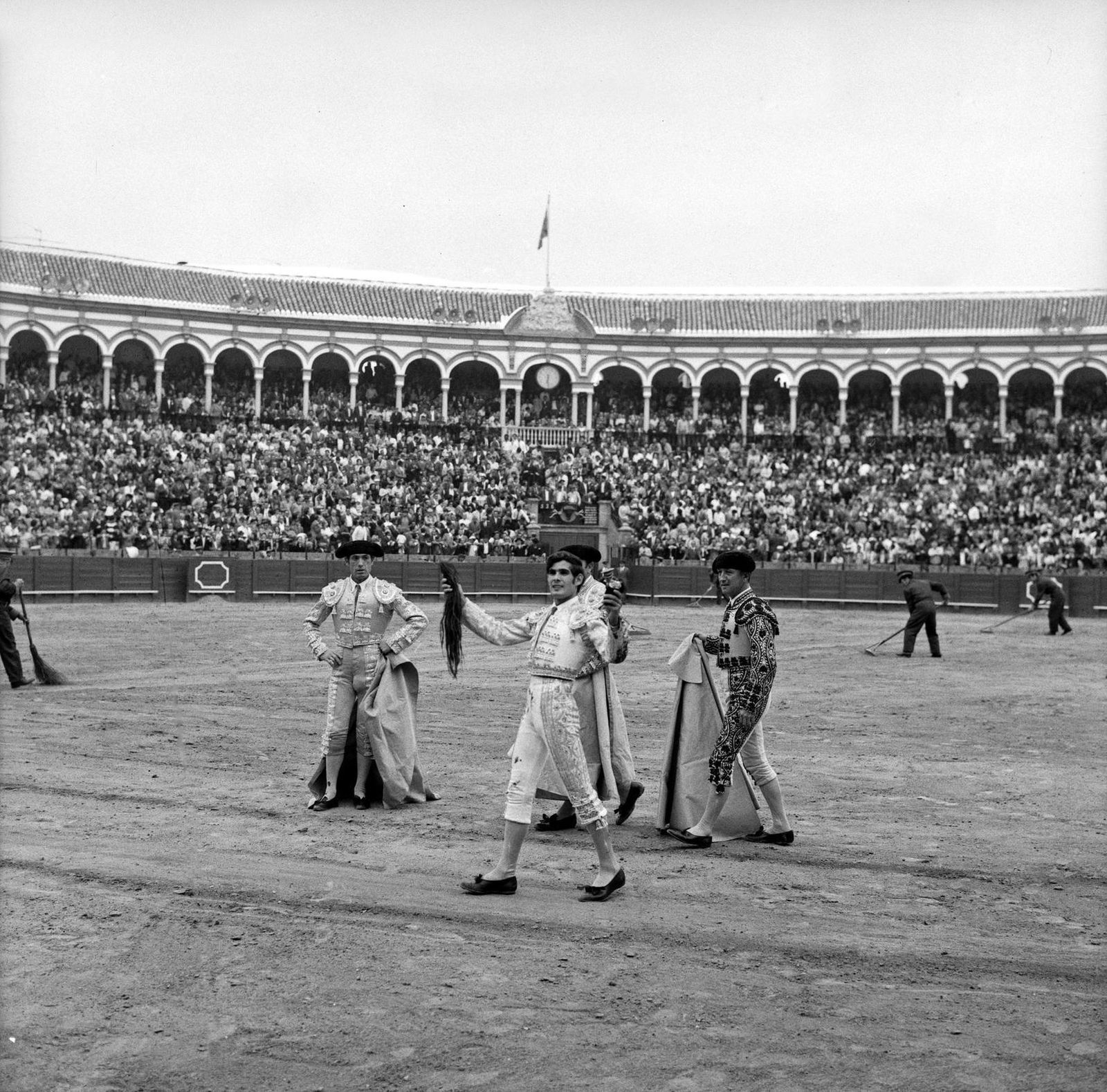 Flanqueado por José Blanco y Manolo Chicuelo, Paco Ruiz Miguel exhibe exultante el rabo de 'Gallero'.