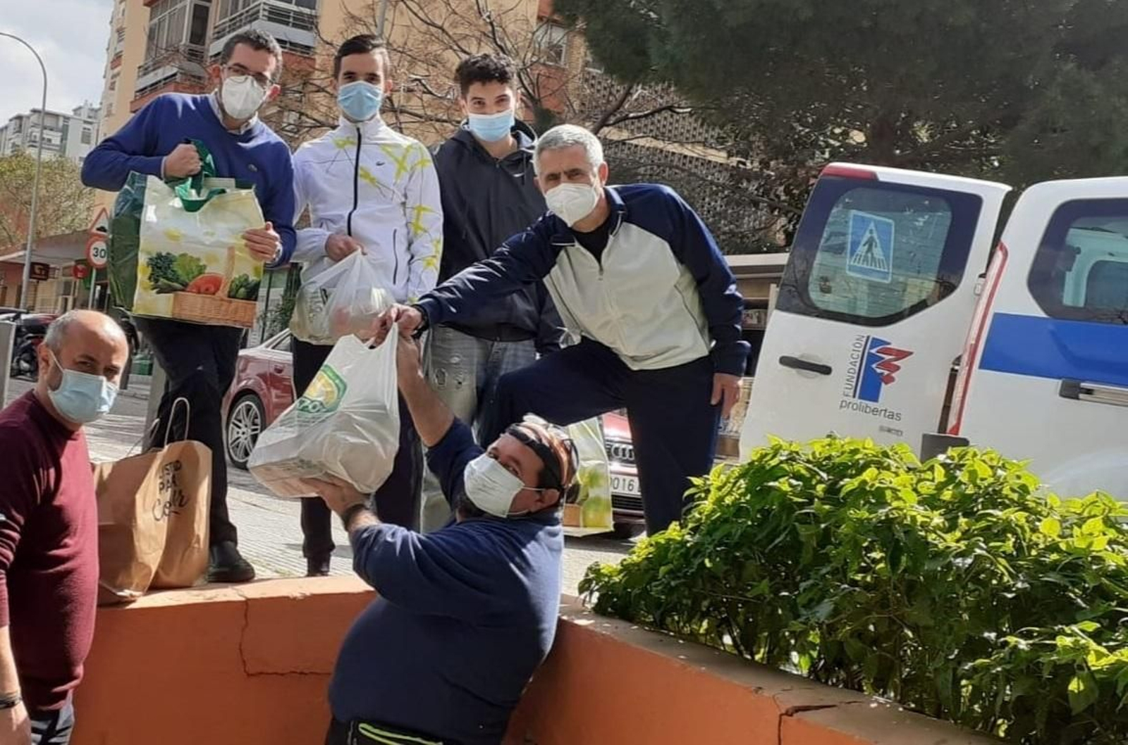 Voluntarios de la hermandad y de Cáritas cargan parte de los víveres, este lunes.