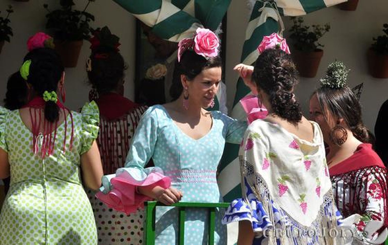 Varias chiccas vestidas de flamenca a las puertas de una caseta.

Foto: Manuel Gómez