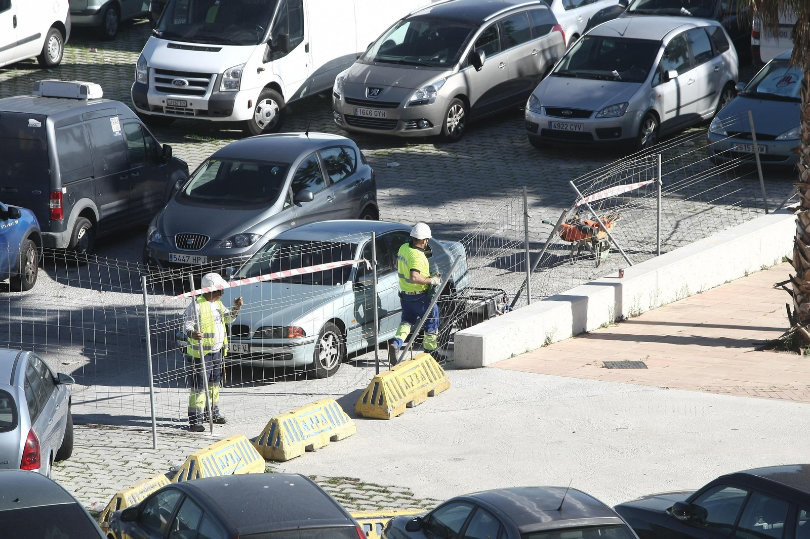 Operarios colocando el vallado en la parcela del Llano, ayer.