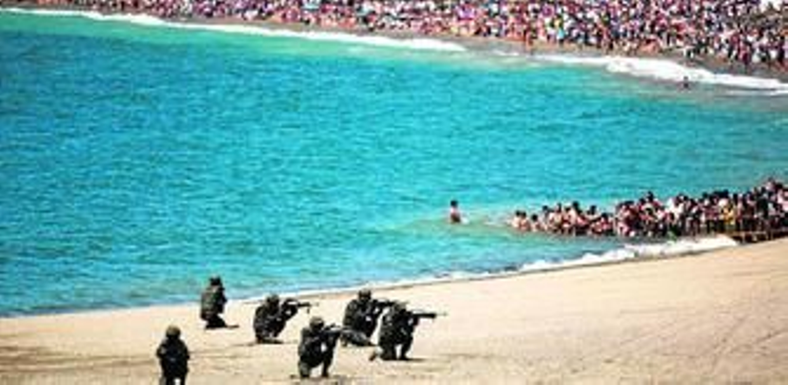 1. La Infantería de Marina, ayer, desplegada en la playa de La Malagueta y al fondo, el público. 2. Un helicóptero durante el rescate de los supuestos observadores retenidos. De la cuerda cuelgan cuatro personas. 3. Tiradores de élite de la Brigada de La Legión descienden de un helicóptero Cougar haciendo rápel, pero boca abajo. 4. Un grupo de equipos de seguridad de la Infantería de Marina avanza sobre la playa con el portaviones 'Príncipe de Asturias' al fondo. 5. Un avión Harrier despega del portaviones 'Príncipe de Asturias' fondeado ayer en la bahía malagueña. 6. Otra imagen del avance conjunto de las distintas fuerzas sobre la playa, con multitud de público agolpado en la orilla.