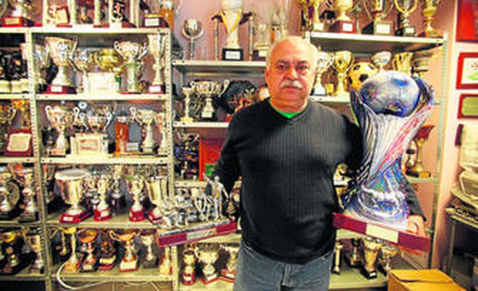 Pepe Justo, presidente del Pueblo Nuevo, posa con dos de los muchos trofeos que el club ha conseguido durante estos treinta años.