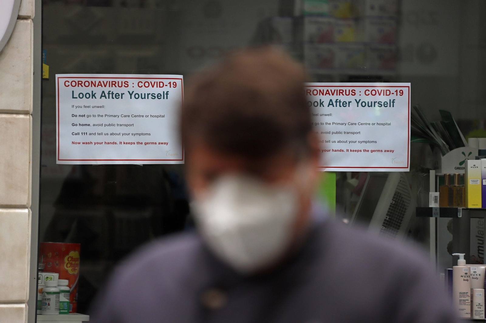 Un ciudadano, ante carteles informativos sobre el Covid-19 en Gibraltar.