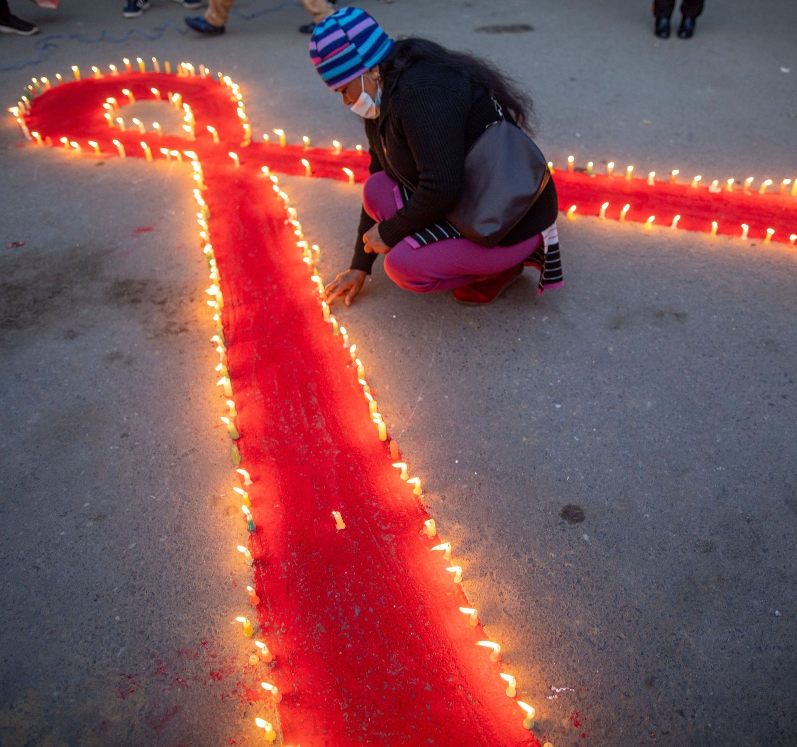 Velas alrededor de un lazo rojo durante en una vigilia con motivo del Día Mundial de Lucha contra el Sida.