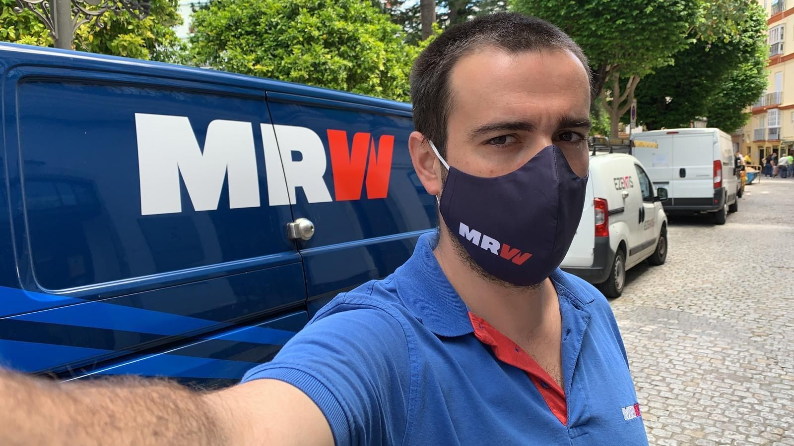 Un repartidor de MRW provisto de su mascarilla en plena jornada de trabajo.