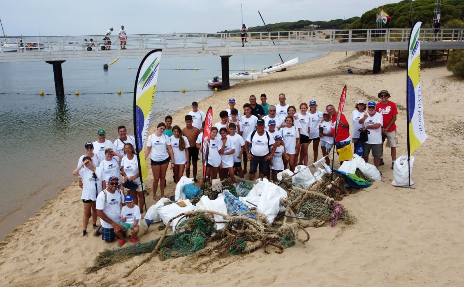 Voluntarios junto a parte de la basura retirada de la Flecha del Rompido
