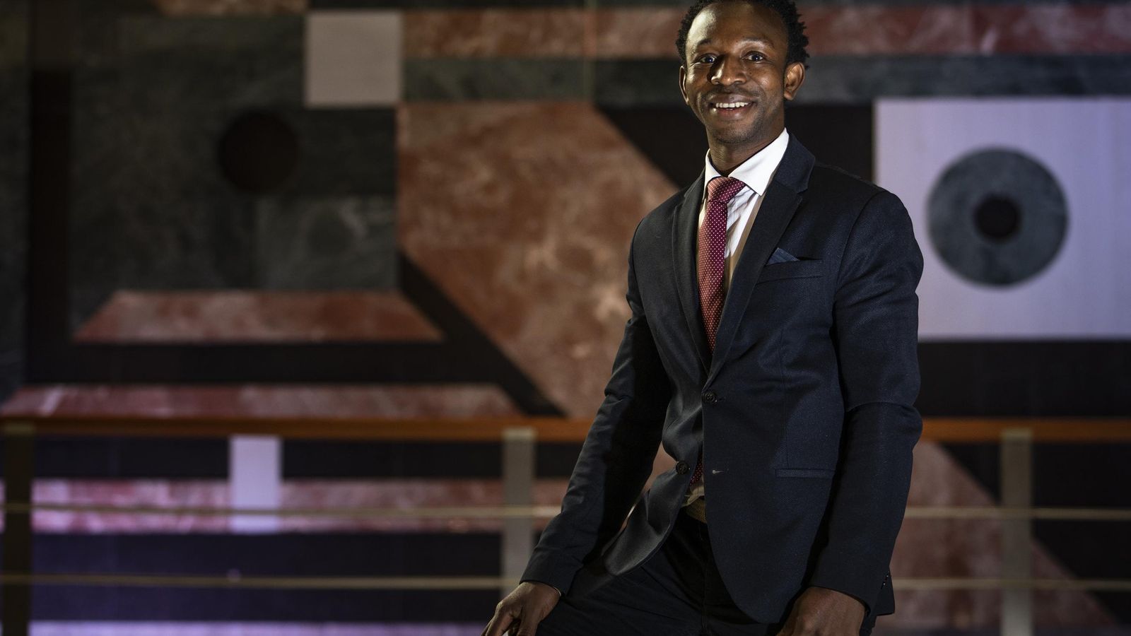 Ousman vestido de traje y corbata posa para Granada Hoy