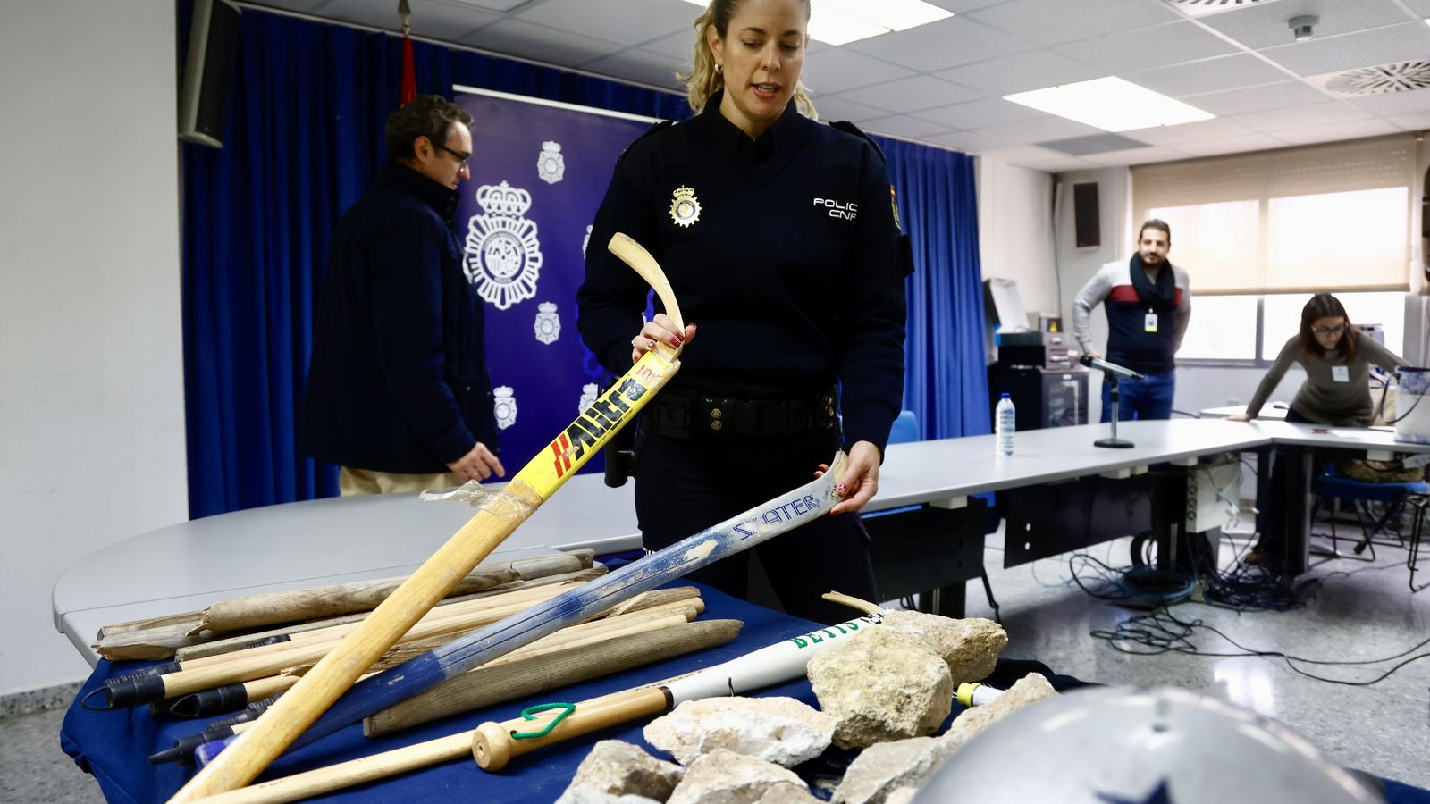 Una agente de la Policía Nacional muestra el material intervenido a los ultras tras la reyerta del parque del Guadaíra.