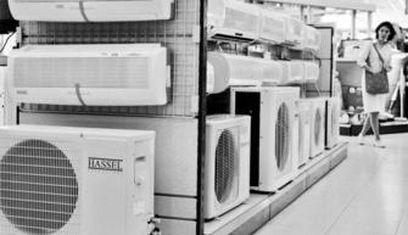 La clienta de un comercio de electrodomésticos se interesa por los aires acondicionados.