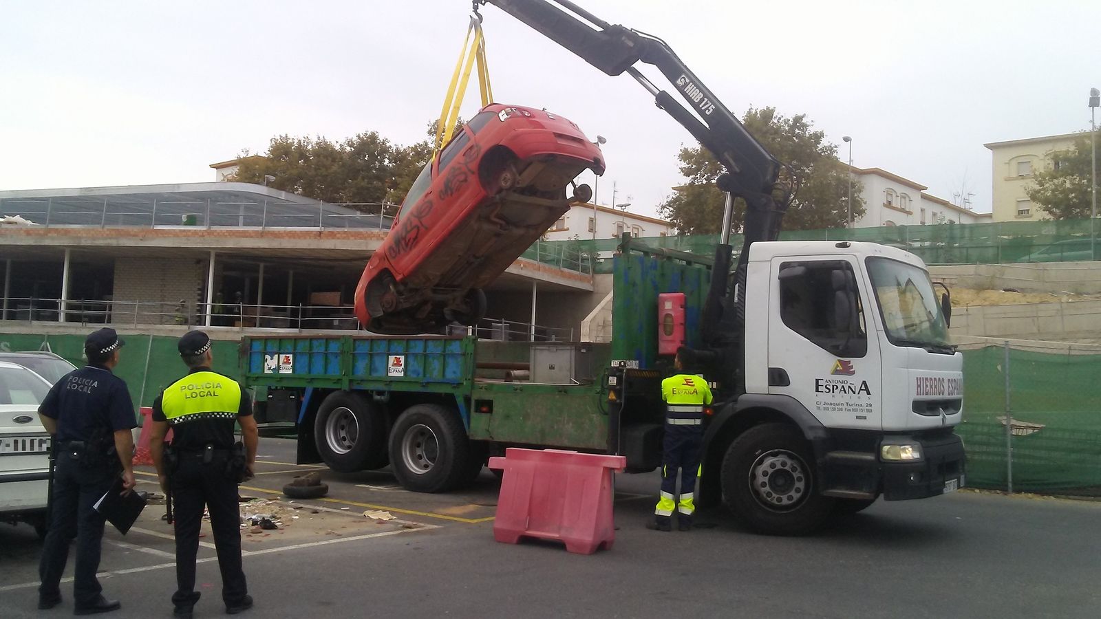 La grúa retira uno de los vehículos en Huelva.