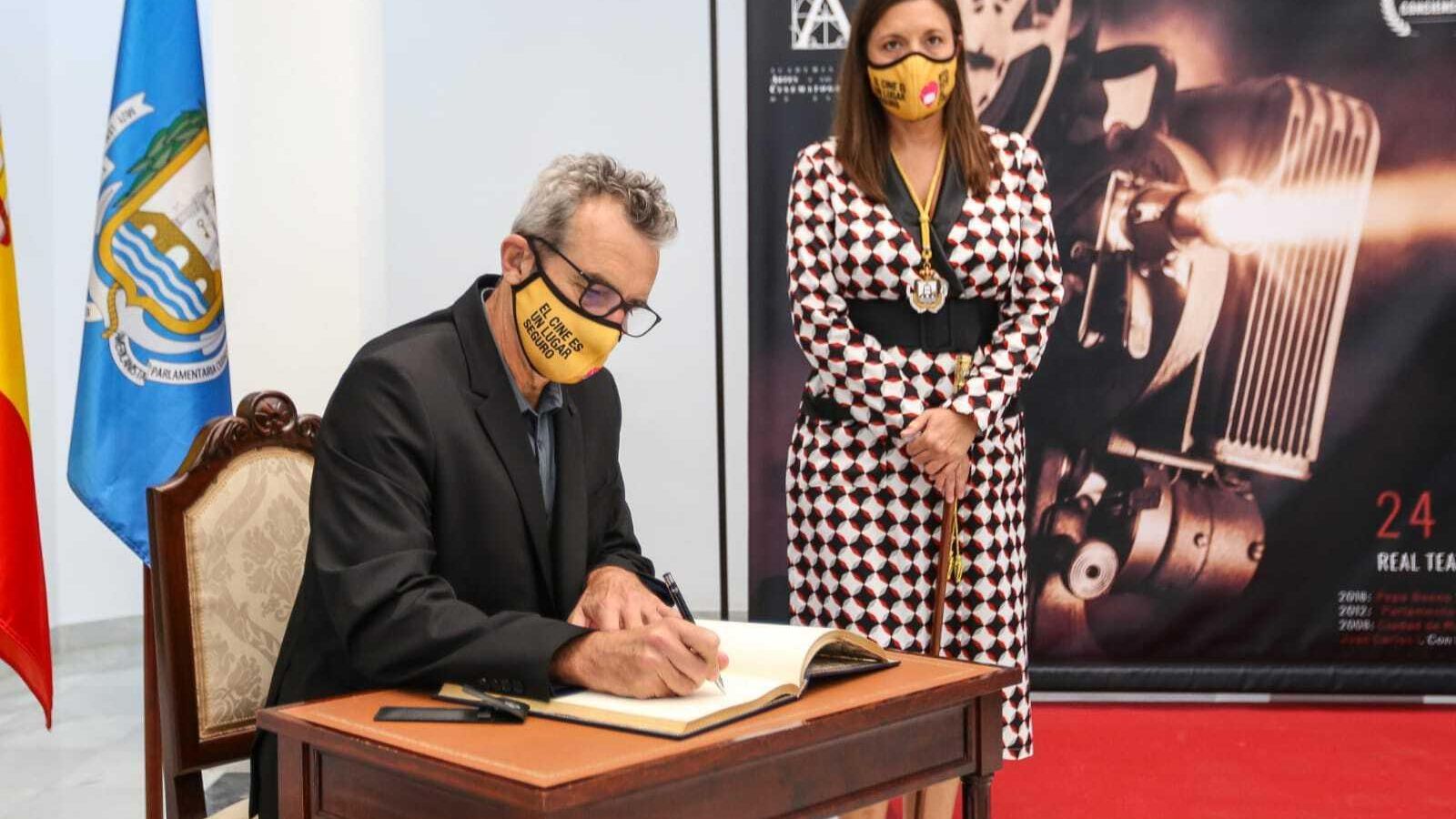 Mariano Barroso, presidente de la Academia de Cine, firma en el Libro de Honor de San Fernando en presencia de la alcaldesa, Patricia Cavada.